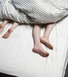 Beine von Jungen unter der Bettdecke - CUF37069