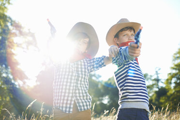 Zwei als Cowboys verkleidete Jungen, die Spielzeugpistolen in der Hand halten - CUF37075
