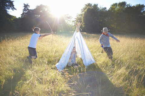 Kleine Gruppe von Jungen spielt um ein Tipi herum, lizenzfreies Stockfoto