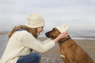 Portrait of mid adult woman and dog on beach, Bloemendaal aan Zee, Netherlands - CUF37124