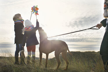 Mid adult man with son, daughter and dog at coast - CUF37129