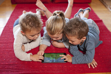 Jungen und ein Mädchen benutzen ein digitales Tablet im Kindergarten - CUF37150