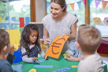 Lehrerin und Schüler zählen im Kindergarten die Euro-Währung - CUF37157