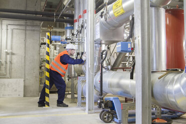 Technician leaning forward during check in power station - CUF37184