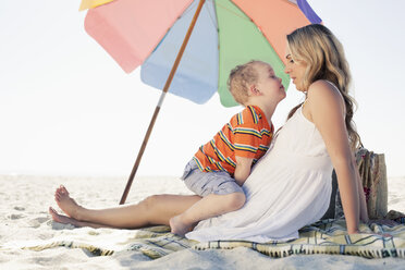 Mid adult mother and son picnic blanket at beach, Cape Town, Western Cape, South Africa - CUF37345