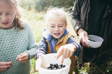 Zwei Mädchen halten Brombeeren in einer Schale - CUF37394