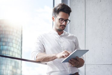 Portrait of businessman using digital tablet - ABIF00666