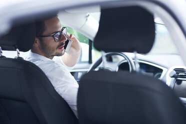 Geschäftsmann sitzt im Auto und telefoniert - ABIF00667