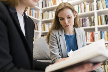 Porträt eines Teenagers in einer öffentlichen Bibliothek, der ein Buch betrachtet - WPEF00494