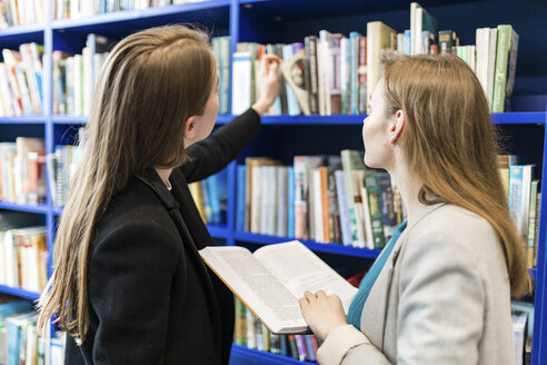 Two teenage girl in a public library choosing books - WPEF00499