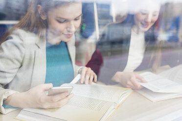 Teenage girls reading books in a public library - WPEF00503