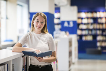 Porträt eines entspannten Teenagers mit Buch in einer öffentlichen Bibliothek - WPEF00506