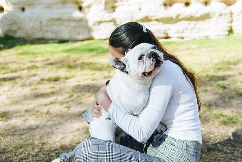 Frau, die ihren Hund umarmt - KIJF01946