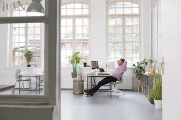 Man working at desk in a loft office - FKF02966