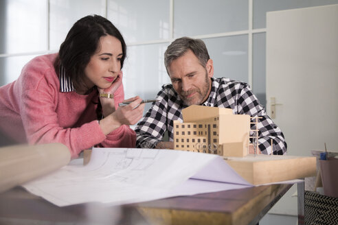 Kollegen begutachten Architekturmodell im Büro - FKF03012