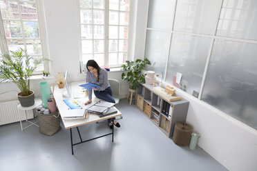 Woman working at desk in a loft office - FKF03021