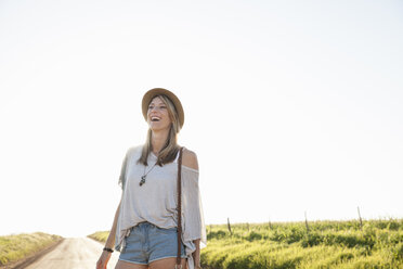 Mid adult woman on country road, laughing - CUF37456