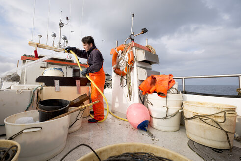 Fischer beim Abspritzen des Fischerboots - CUF37488