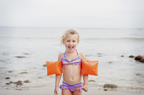 Junges Mädchen mit Armbinden am Strand, lizenzfreies Stockfoto