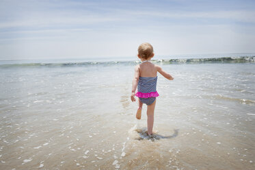 Female toddler running into the sea - ISF14581