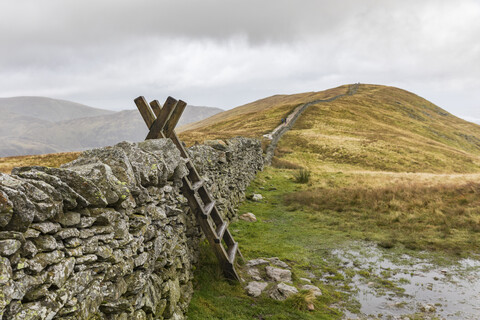 United Kingdom, England, Cumbria, Lake District, wood ladder, stone wall on the way to Helvellyn stock photo