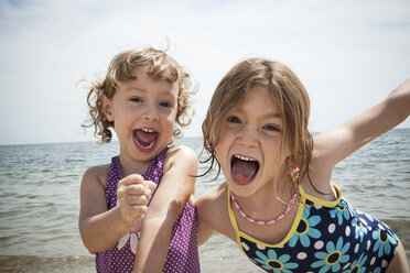 Portrait of two sisters pulling faces on beach at Falmouth, Massachusetts, USA - ISF14654