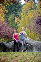 Yogalehrer unterrichtet junge Frau im Wald - ISF14750
