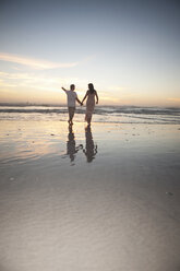 Händchenhaltendes Paar am Strand bei Sonnenuntergang, Kapstadt, Südafrika - ISF14772