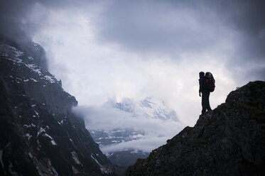 Mann stehend auf Felsen mit dem Eiger im Hintergrund, Berner Oberland, Schweiz - ISF14811