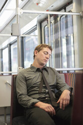 Mid adult office worker snoozing on train journey - ISF14942