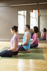 Kniende Menschen im Yoga-Kurs - ISF14958