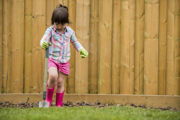 Junges Mädchen gräbt Erde im Garten - ISF15111