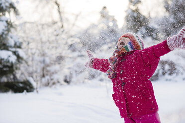 Young girl shouting and throwing snow mid air - ISF15124