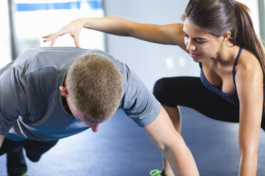 Paar hilft sich gegenseitig im Fitnessstudio - ISF15151
