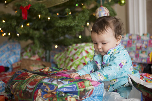 Kleines Mädchen beim Öffnen der Geschenke an ihrem ersten Weihnachten - ISF15172