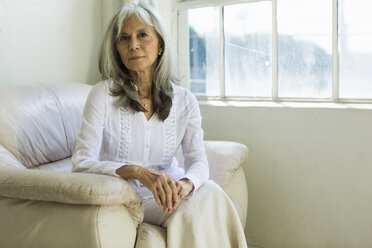 Porträt einer älteren Frau, die in einer Wohnung sitzt - ISF15176