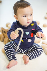 Baby Mädchen sitzt auf dem Boden mit Spielzeug - ISF15183