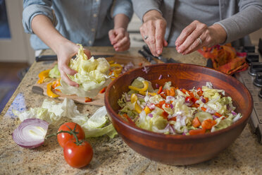 Ältere Frau und Enkelin hacken Gemüse für Salat - ISF15214