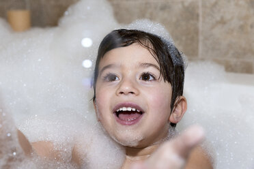 Young boy trying to catch bubble in bubble bath - ISF15220