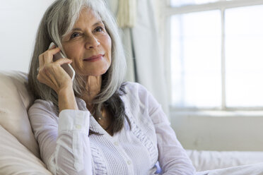 Porträt einer attraktiven älteren Frau, die mit ihrem Smartphone chattet - ISF15233