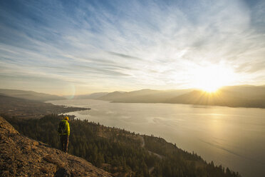 Männlicher Wanderer beobachtet den Sonnenuntergang über dem Okanagan Lake, Naramata, British Columbia, Kanada - ISF15253
