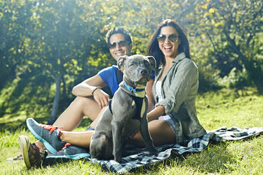 Porträt eines Paares mit Hund auf einer Picknickdecke im Park - ISF15288