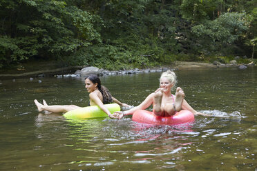 Frauen im Fluss mit aufblasbaren Ringen - ISF15324