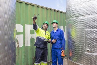 Arbeiter mit Tablet am Container im Gespräch mit einem Kollegen - ZEF15743