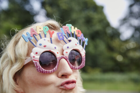 Schmollende Frau mit Geburtstagsbrille, lizenzfreies Stockfoto