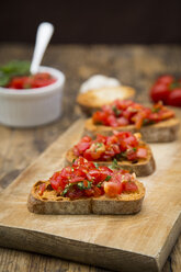 Bruschetta with tomato and basil on wooden board, close up - LVF07176