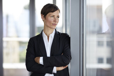 Geschäftsfrau im Büro schaut aus dem Fenster - RBF06358