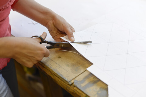 Close-up of woman cutting paper from draft in glazier's workshop stock photo