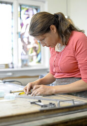 Frau bei der Arbeit an der Werkbank in einer Glaserwerkstatt - BFRF01868