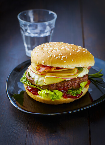 Cheeseburger mit Apfel und Speck auf dem Teller, lizenzfreies Stockfoto